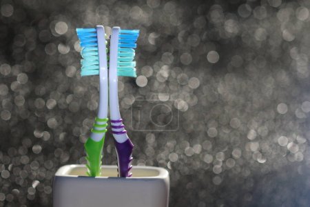 Toothbrushes isolated on the bokeh background. Nylon bristles and plastic handles. Blank copy space for advertising text.