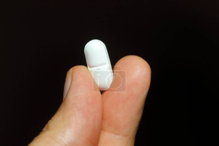 Photo for Hand holding a pill or supplement - Royalty Free Image