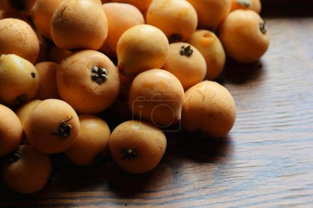 ripe loquat fruits on wooden table