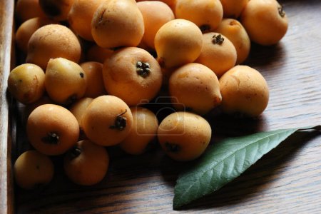 ripe loquat fruits on wooden table