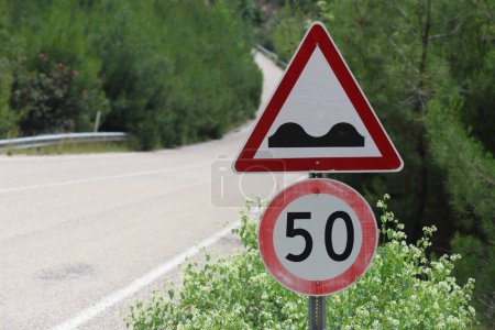 bumpy road signpost. speed limit 50