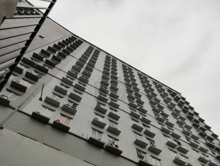 Foto de Edificio de apartamentos gris enorme con cielo nublado o malhumorado - Imagen libre de derechos