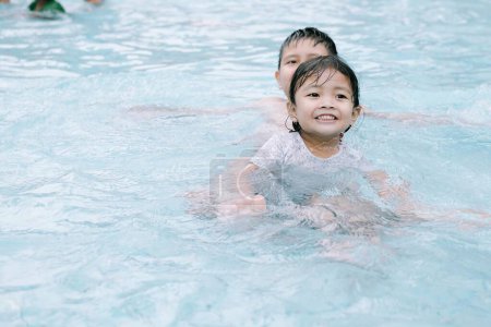 Foto de Dos niños del sudeste asiático jugando en el agua en una piscina. Enfoque suave o desenfocado. - Imagen libre de derechos