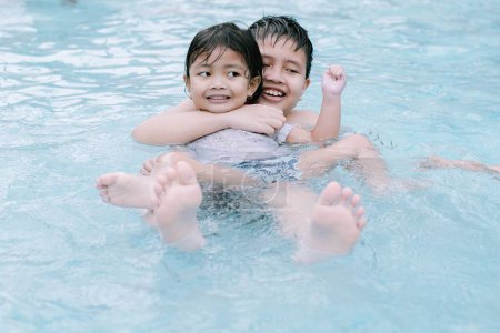 Foto de Dos niños del sudeste asiático jugando en el agua en una piscina. Enfoque suave o desenfocado. - Imagen libre de derechos