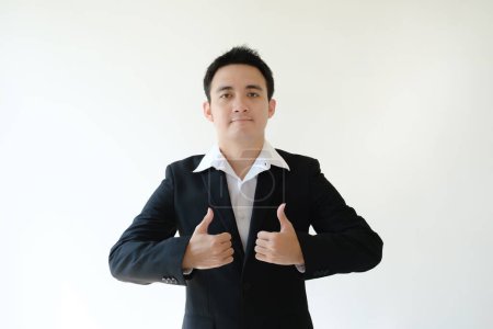Foto de Un joven empresario asiático está dando dos pulgares hacia arriba por sus dos manos a la cámara. Fondo blanco aislado. - Imagen libre de derechos
