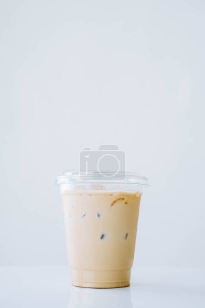 Foto de Retrato o toma vertical de un café con leche helado sobre una taza de plástico desechable y un fondo blanco aislado - Imagen libre de derechos