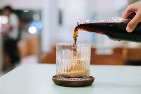 Foto de Captura selectiva de foco de verter una botella de cerveza en un vaso con un fondo y un primer plano borroso - Imagen libre de derechos
