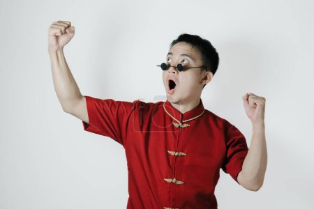Photo for Asian man wearing traditional costume with excited gesture and face expression on white background. Chinese New Year concept. Gong Xi Fa Cai. - Royalty Free Image