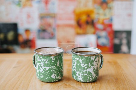 Foto de Café en taza de acero indonesio vintage con patrón verde aleatorio llamado taza Blirik o cangkir Blirik sobre fondo bokeh - Imagen libre de derechos