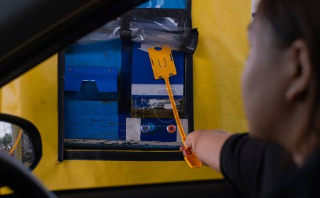 Photo for Pay on toll collection point or toll booth using card placed on a stick to tap from inside the car - Royalty Free Image