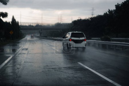 Foto de Coche blanco conduciendo por el camino mojado. Desenfocado, bokeh o borroso. - Imagen libre de derechos