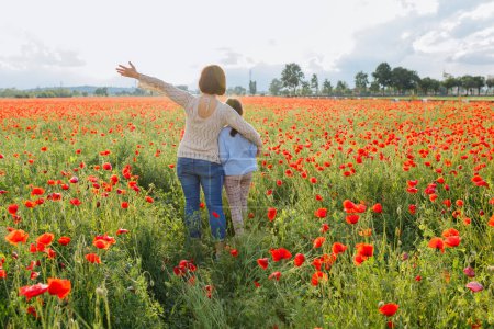 rear view of woman and child standing in the poppy field with stretched arms