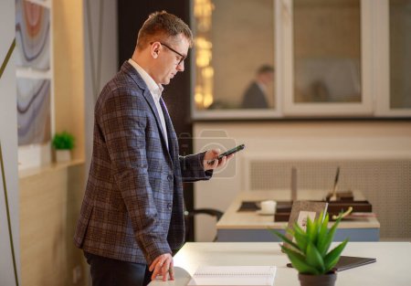 Businessman typing a text message on a smartphone, online work, office - manager.
