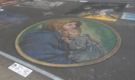 Photo for Grazie di Curtatone (Mantua), 15 August 2017: street artist who paints on the asphalt in the Madonnari chalk painting competition. - Royalty Free Image