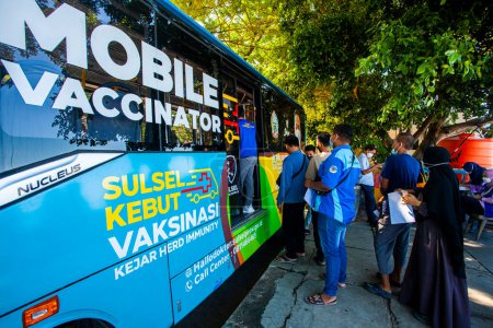 Photo for People in Makassar City queue up to get free COVID-19 vaccinations through the mobile vaccinator, a program from the Indonesian government. - Royalty Free Image