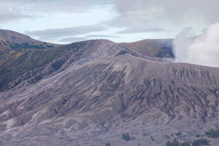Foto de Monte Bromo con una bocanada de humo de su caldera. Fotografiado de cerca para ver los detalles naturales. La zona de Bromo Tengger Semeru es un destino turístico popular en Java Oriental, Indonesia. - Imagen libre de derechos