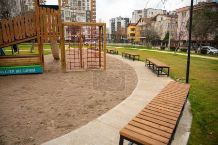 Téléchargez les photos : Children's playground in the city , children's entertainment area with play sand floor , modern playground made of wood. High quality photo - en image libre de droit