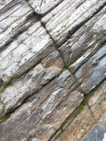 Hintergrund grauer Gesteinsschichten, geologische Steinmauer, die sich im Laufe der Zeit gebildet hat. Hochwertiges Foto