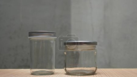 Two empty jars with lid on wooden table