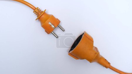 Photo for Bright orange extension cord on a white surface. Cable isolated on white background. - Royalty Free Image