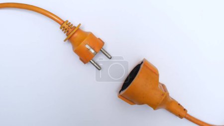 Téléchargez les photos : Corde d'extension orange vif sur une surface blanche. Câble isolé sur fond blanc. - en image libre de droit