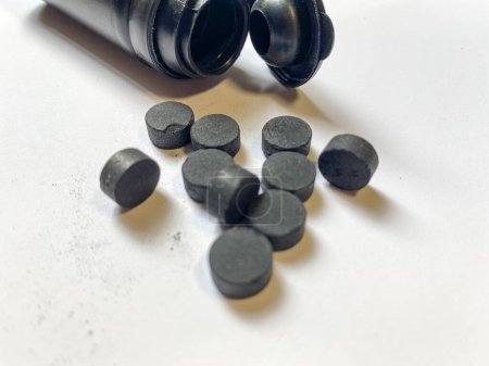 Téléchargez les photos : Pilules de charbon activé sur fond blanc. Sorbant puissant - en image libre de droit