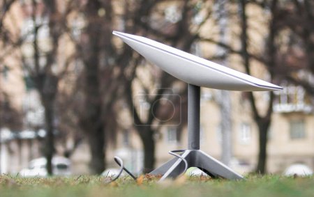 Foto de Una antena para recibir la señal de Internet desde el espacio Starlink en el suelo en el parque - Imagen libre de derechos