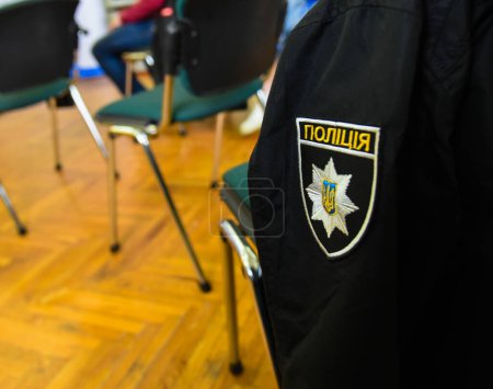 Foto de Logo de la policía ucraniana (la inscripción "Policía" en ucraniano) en el uniforme de un policía - Imagen libre de derechos