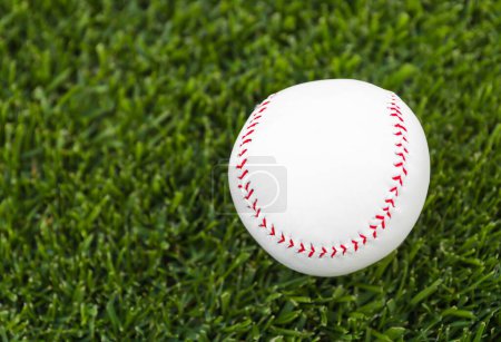 Game ball for playing baseball on green grass