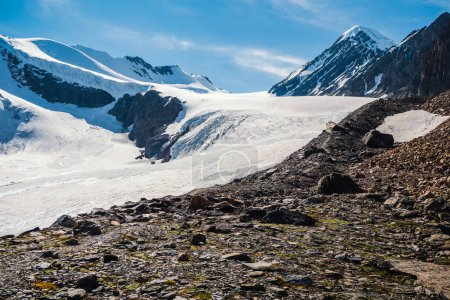 Téléchargez les photos : Le chemin vers le glacier Aktru. Plateau enneigé de haute altitude. Paysage alpin avec sommet enneigé et rochers pointus sous le ciel bleu. Paysage de montagne ensoleillé coloré avec sommet de montagne de neige. - en image libre de droit