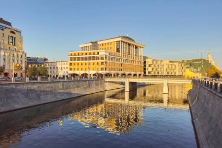 Helle Stadtansichten, das Gebäude bei Sonnenuntergang spiegelt sich im Wasser des Flusses. Moskauer Geschäftszentrum Baltschug Plaza. 