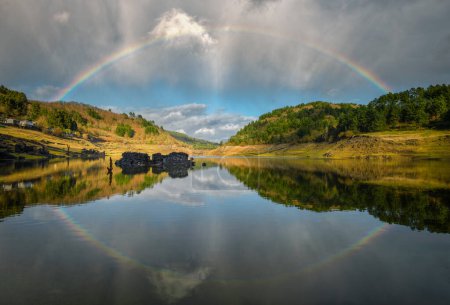 Un arc-en-ciel complet et son reflet dans la rivière près de Portomarin Lugo Galice