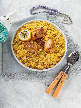 Chicken Biryani with Spices and Lemon on White Plate, Concrete Background, Copy Space
