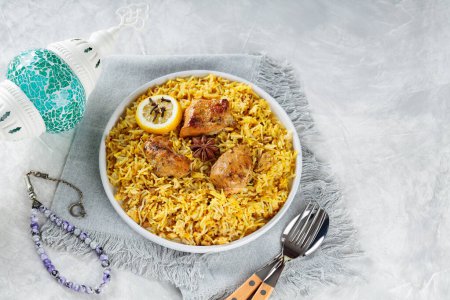 Chicken Biryani with Spices and Lemon on White Plate, Concrete Background, Copy Space