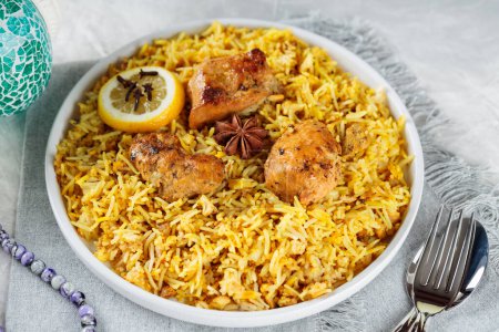 Plate of Traditional Chicken Biryani with Cutlery on Gray Background, Close-up