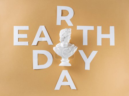 Earth Day Inschrift und antike Büste auf beigem Hintergrund, Umweltschutzkonzept