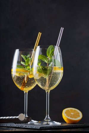 Refreshing Hugo Spritz Cocktail with Elderflower Liqueur, Mint and Lemon on Dark Background