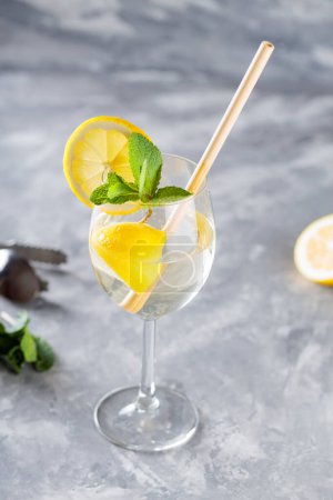 Cocktail Hugo Spritz en verre garni de menthe et de citron, boisson alcoolisée rafraîchissante froide d'été