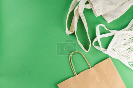 Cotton and Paper Bags on Green Background, Sustainable Zero Waste Lifestyle Concept