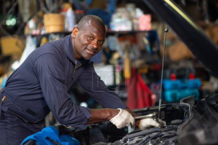 Foto de Portrait garage mechanic professional worker car engine service looking camera smile - Imagen libre de derechos