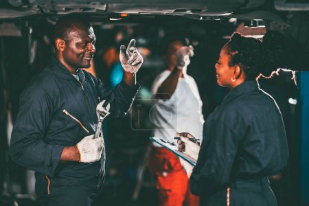 Foto de Taller mecánico equipo de trabajo coche auto servicio negro africano trabajador profesional juntos - Imagen libre de derechos
