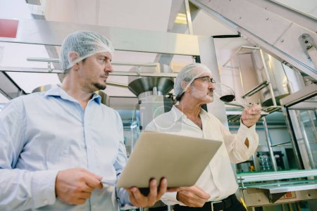 Winzer professionelle Standard-Offiziere arbeiten chek Hygienequalität der Getränkeherstellung in Linie Getränkefabrik