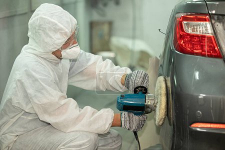 Foto de Garaje coche color reparación abrigo de cera y brillante equipo de pulido personal que trabaja en taller de automóviles - Imagen libre de derechos