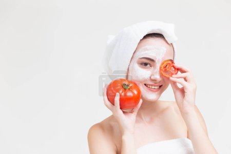 Téléchargez les photos : Belle femme avec soin du visage de Lycopène tomate et vitamine carotène pour une peau saine. - en image libre de droit