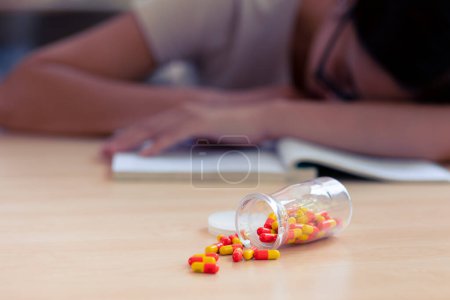 Photo for Young teen student with medicine drug capsule pill for pain relief or reduce stress from studying hard. - Royalty Free Image