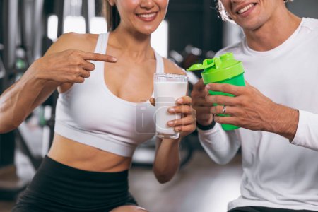 Téléchargez les photos : Sport personnes saines montrent comparer lait et protéines de lactosérum shake sont une bonne boisson repas alimentaire pour le renforcement musculaire du corps gain de masse - en image libre de droit