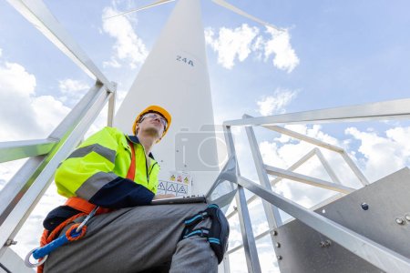 Foto de Ingeniero profesional técnico masculino que trabaja usando el control del sistema de turbinas eólicas de configuración portátil operar el servicio en el sitio de la ubicación - Imagen libre de derechos
