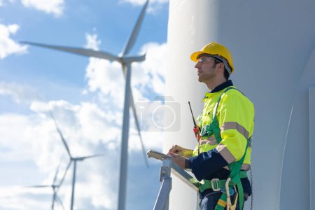 Foto de Ingeniero inteligente y confiado equipo de servicio de aerogeneradores macho mirando al cielo hacia el futuro del concepto de energía limpia - Imagen libre de derechos