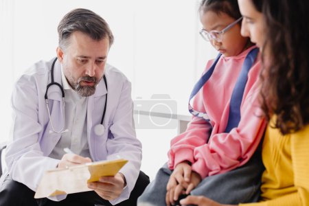 Photo for Mother with daughter meeting pediatrician doctor at the clinic for health check talking about mental problems. - Royalty Free Image