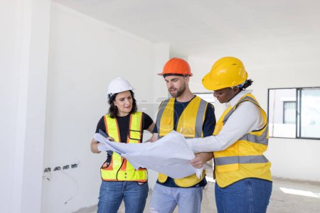 Photo for Group of professional construction workers engineers team meeting standing together work in new house construction site with floor plan. - Royalty Free Image